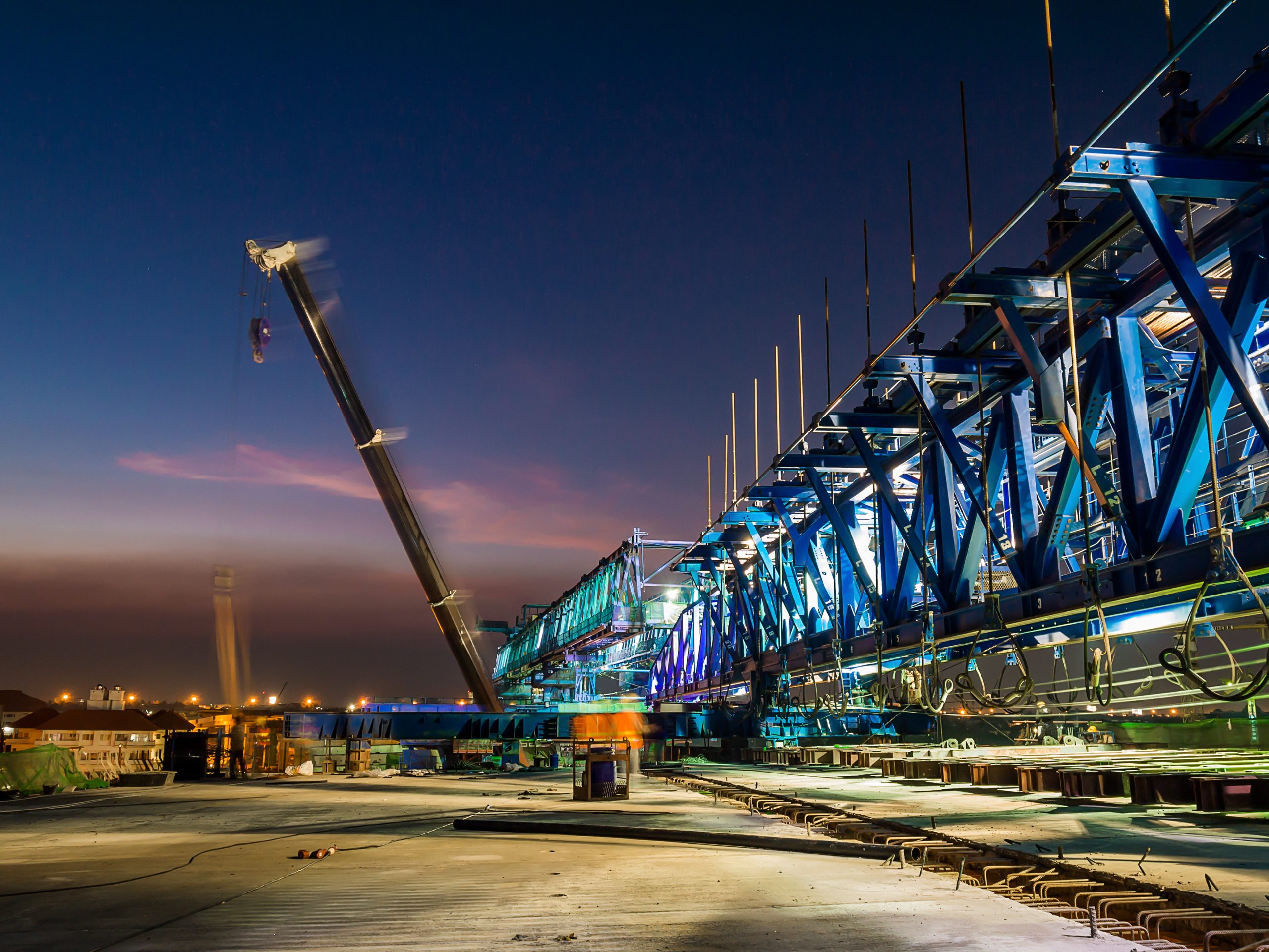 Express way construction site while bridge girder erection machine working at twilight